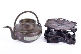 A Chinese brass kettle with white metal decoration.