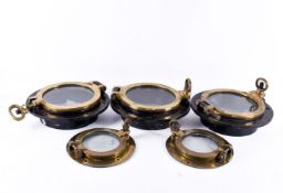 A group of five ship's brass port holes.