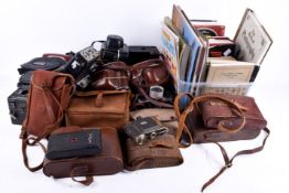 A collection of vintage film cameras and a quantity of books related to photography.