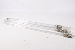 A set of four contemporary clear perspex curtain poles.