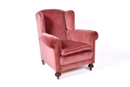 A pink velvet upholstered wingback armchair.