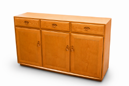 Ercol Windsor sideboard. Having three drawers over three panel doors.