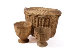 Three assorted wicker baskets. Including a large laundry basket and two urn shaped baskets.