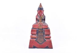 A Cambodian Khmer painted wooden figure modelled as a traditional seated buddha on stand.