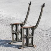 A pair of cast iron bench ends, with pierced sides.