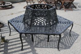 A 20th century black painted cast iron 'tree' bench of hexagonal form.