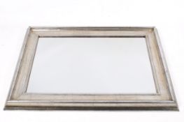A contemporary wall mirror with mottled silver frame.