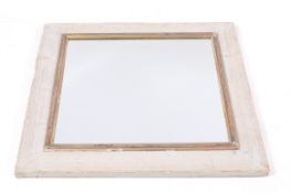 A rustic mirror with whitewashed solid wooden frame.