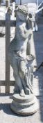 A reconstituted stone garden statue of Venus with a separate circular plinth.