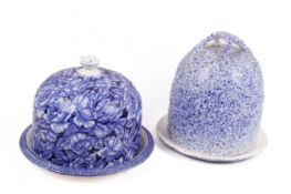 Two blue and white ceramic cheese bells on stands.