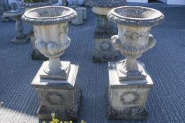 Pair of composition stone garden 'campana' urns on plinths.