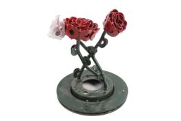 A contemporary welded metal roses sculpture with red and white flower heads on green base.