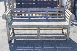 A Lutyens style teak slatted garden bench.
