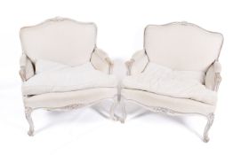 A pair of Louix XVI style armchairs with scroll arms and neutral upholstery,