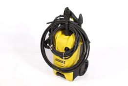 A Karcher K4 Compact pressure washer with hose and various head attachments