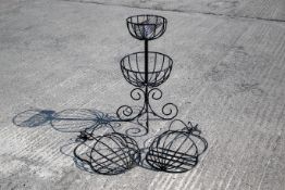 A two tier black metal garden planter and two wall mounted baskets.