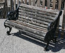 A slatted garden bench flanked by cast iron ends and decorative floral motifs.