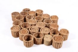 A quantity of twenty-six small wicker storage baskets with lids.