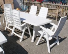White plastic garden patio table and set of six Hartman Carlton folding chairs.