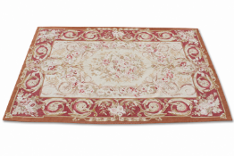 An Aubusson wool rug having floral borders and medallion on a cream ground.