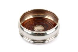 A silver mounted wood coaster. Hallmarks for London 2001, diameter at widest part 9.
