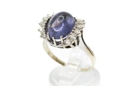 A dress ring set centrally with a blue cabochon.