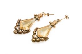 A pair of Victorian citrine and yellow metal drop earrings. The kite shaped faceted stones circa 2.