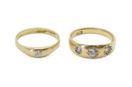 Two yellow metal and diamond set dress rings. One with three mixed round cut diamonds of 0.
