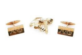 A pair of yellow metal cufflinks and a bow brooch. The cufflinks engraved 'P.