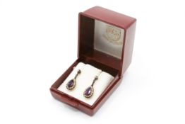A pair of pear shaped drop earrings set with amethyst and seed pearls. Post and butterfly fittings.