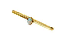 A 9ct gold and opal bar brooch. The central opal circa 7mm x 4mm, width of brooch 4.