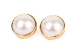 A pair of mabe pearl earrings. With yellow metal clip fittings marked 18K and tested as 18ct gold.