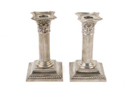A pair of short weighted silver candlesticks.
