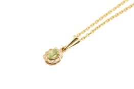 A yellow metal peridot pendant and chain.