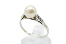A white metal and cultured pearl dress ring. The pearl circa 7.