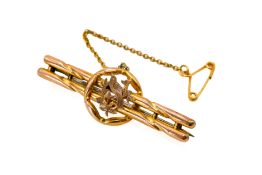A 9ct gold bar brooch. Featuring a central bird within a roundel, marked 9ct to the back, L4.