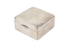 A square silver mounted cigarette box. Lined in wood, the lid with engraved monogram C.J.