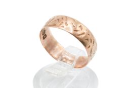 A 9ct rose gold ring. With textured decoration to the band, width 5.