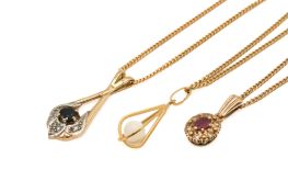 Three 9ct gold and yellow metal pendants.