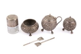A three-piece Indian or Persian white metal cruet set with two spoons, and a silver lidded pot.