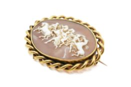 A Victorian yellow metal mounted cameo brooch carved with the Hours leading the Horses of the Sun.