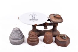 A set of kitchen / shop balance scales with ceramic plate and weights.