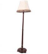 A mahogany standard lamp, raised on a circular base.
