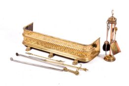 Brass fire fender with claw feet and fireside set of tools.