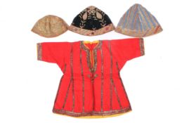Two 19th/20th century Persian quilted caps, a child's tunic and a cap.