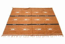 A South American 1st Choice hand woven wool rug on a brown ground. With traditional motifs.