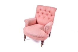 A Victorian button back pink upholstered armchair.