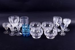 A collection of assorted drinking glasses, mostly with engraved grape and vine decoration.
