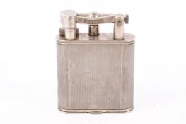 A white metal Dunhill table lighter.