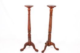 A near pair of mahogany Victorian style torchere stands.